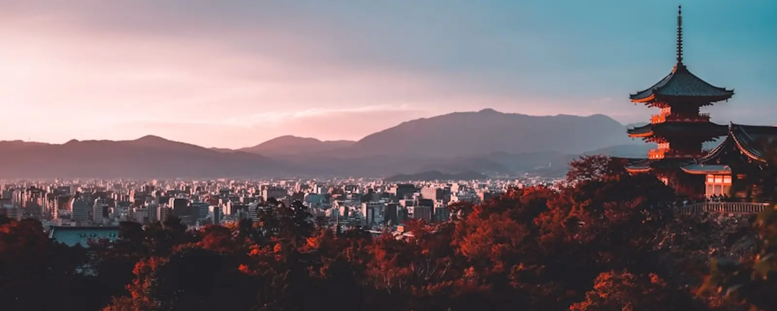 Kyoto cityscape at dusk with mountains behind
