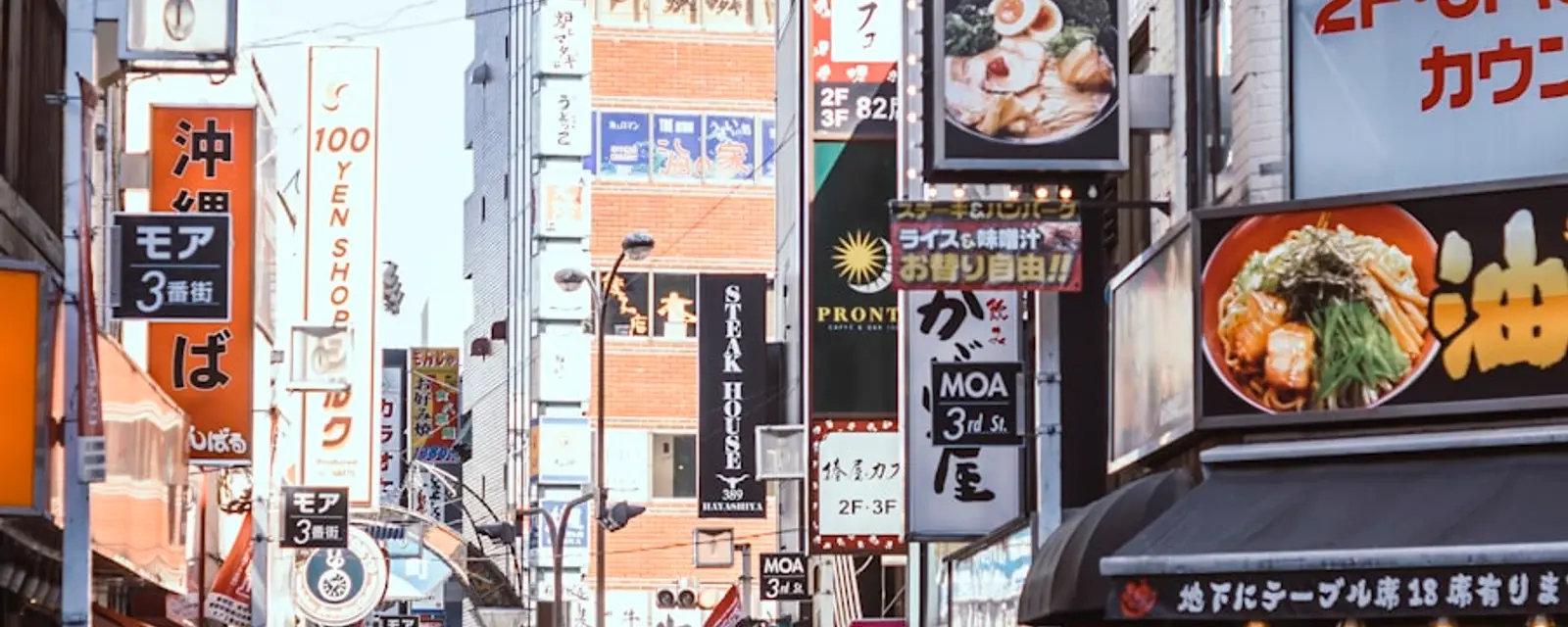 A busy Shinjuku street lined with layered restaurant signboards