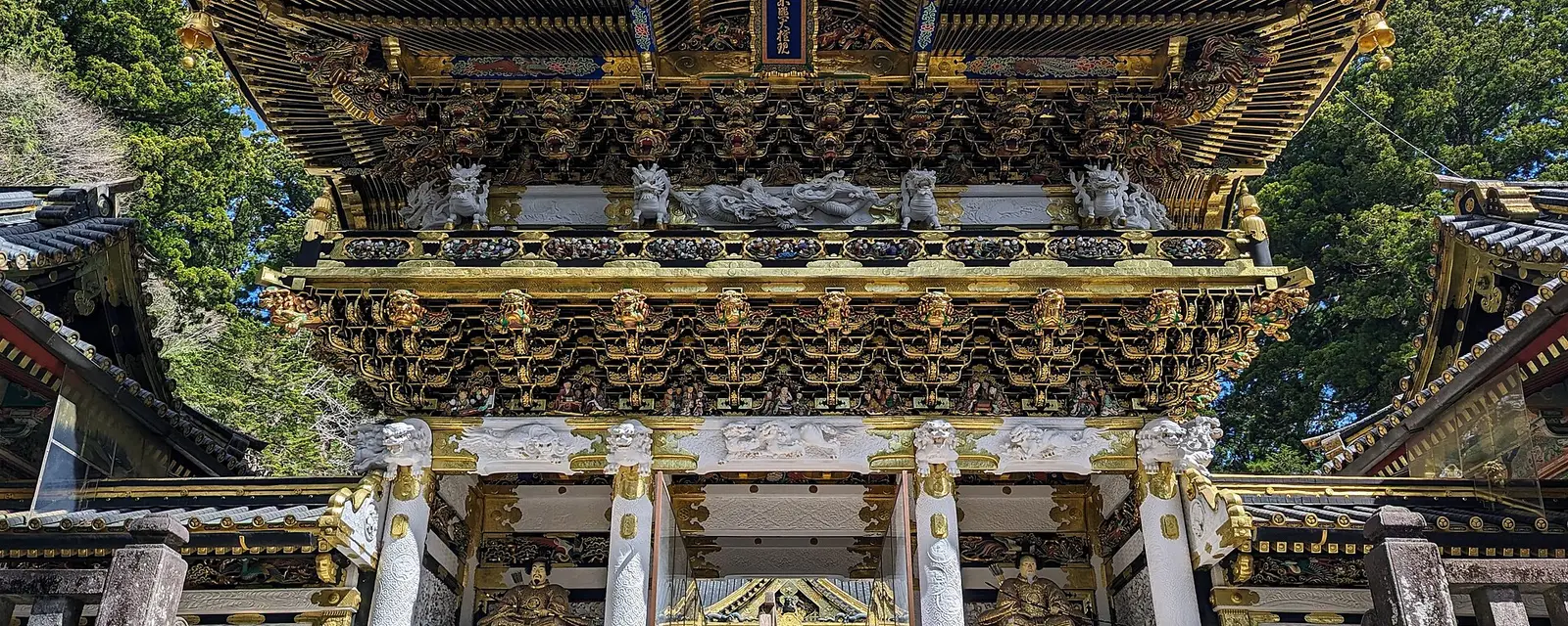 The gold-covered Yomeimon gate at Nikko Toshogu shrine under blue sky