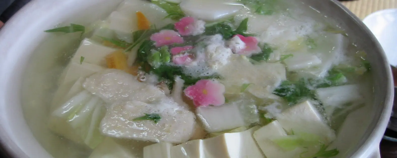 A steaming clay pot of yudofu tofu hotpot with vegetables at a Kyoto temple